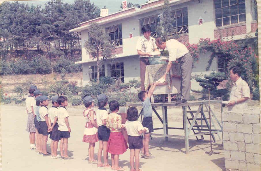사진은 1970년대 부강초 아침조회 풍경. 철제연단에 서계신 교장선생님이 학생들에게 상장을 주고 있다.