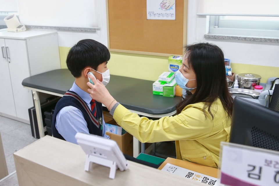 세종시 아름중 보건교사가 학생의 체온을 확인하고 상담하고 있는 장면
