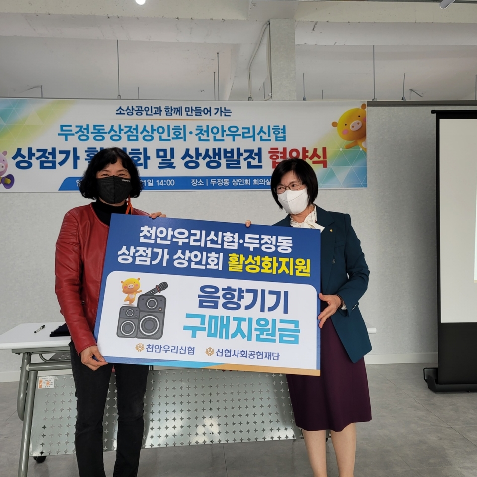 천안우리신협에서 두정동상점가상인회 음향기기 구매지원금을 전달하는 모습
